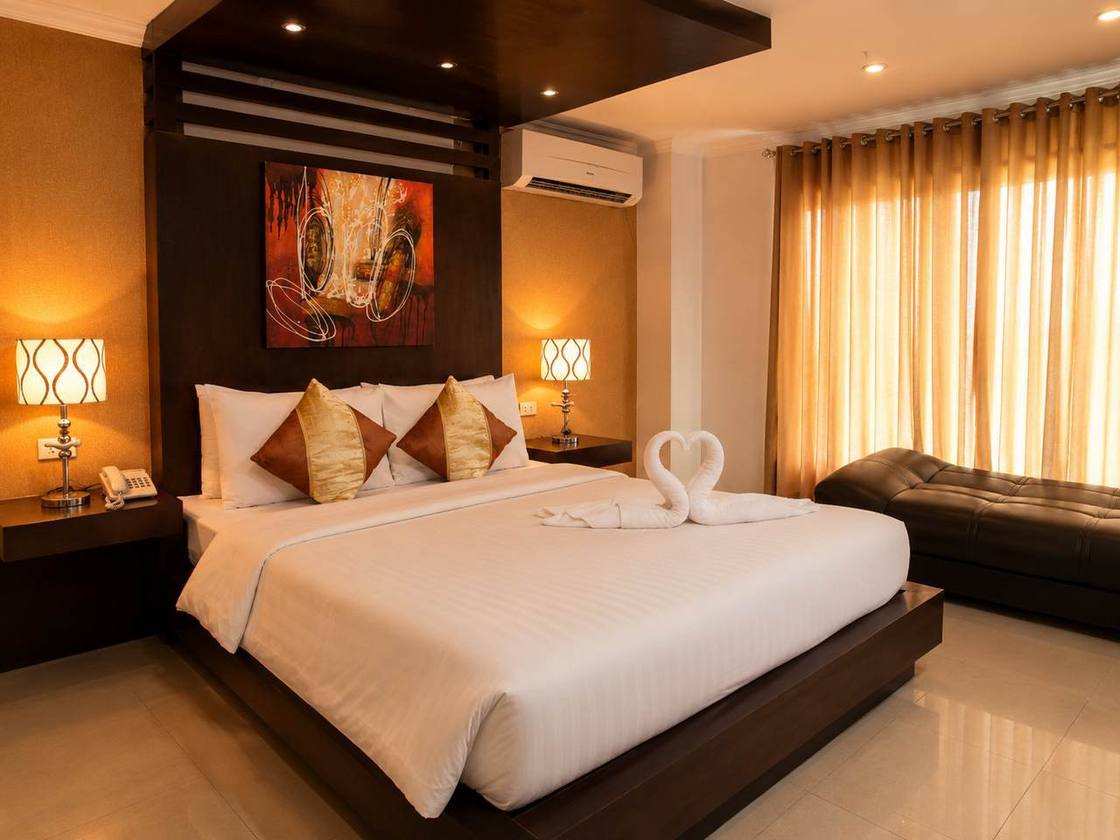 Warmly lit guest room with large bed and lounge seating