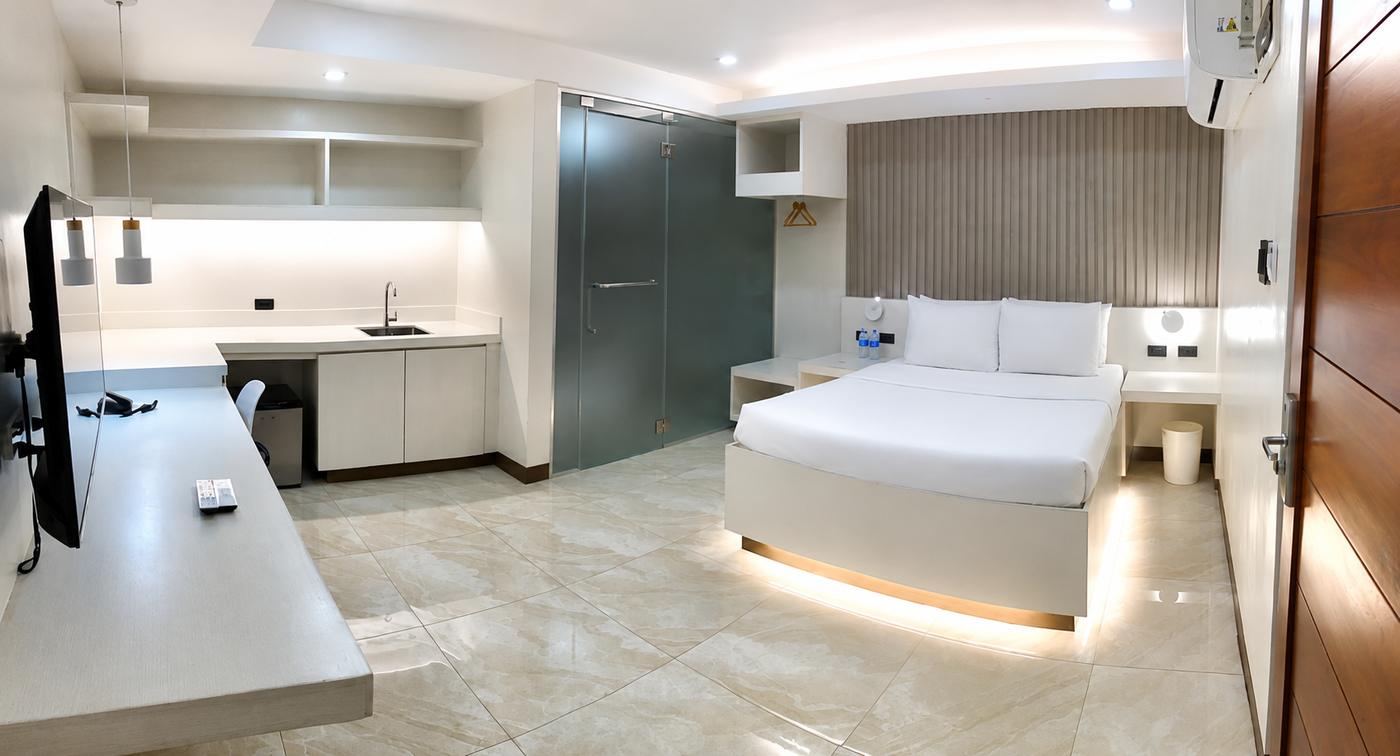 King-bed interior with desk, sink, and bright tiled floor
